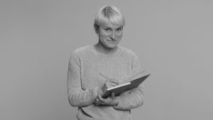 A person poses with a journal in hand