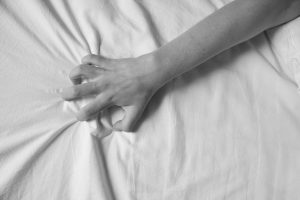Hand gripping bed sheet