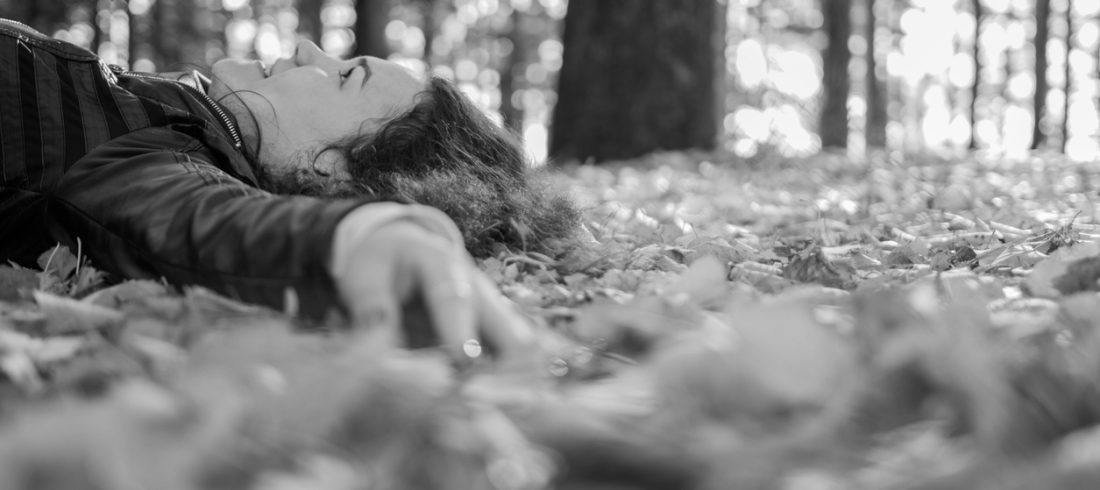 Person lying down in the fall leaves