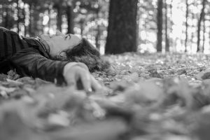 Person lying down in the fall leaves